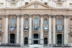 Banners with the official images of (L to R) Sister Irmã Dulce Pontes, Mother Giuseppina Vannini, John Henry Newman, Mother Mariam Thresia and Marguerite Bays hang on the facade of St. Peter's Basilica Oct. 10, 2019, three days before their canonization.