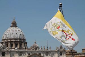 A Vatican City flag flies in view of St. Peter’s Basilica in Rome.