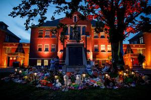 A makeshift memorial to honour the 215 children whose remains have been discovered buried near the facility is seen as orange light drapes the facade of the former Kamloops Indian Residential School in Kamloops, British Columbia, Canada, on June 2, 2021.