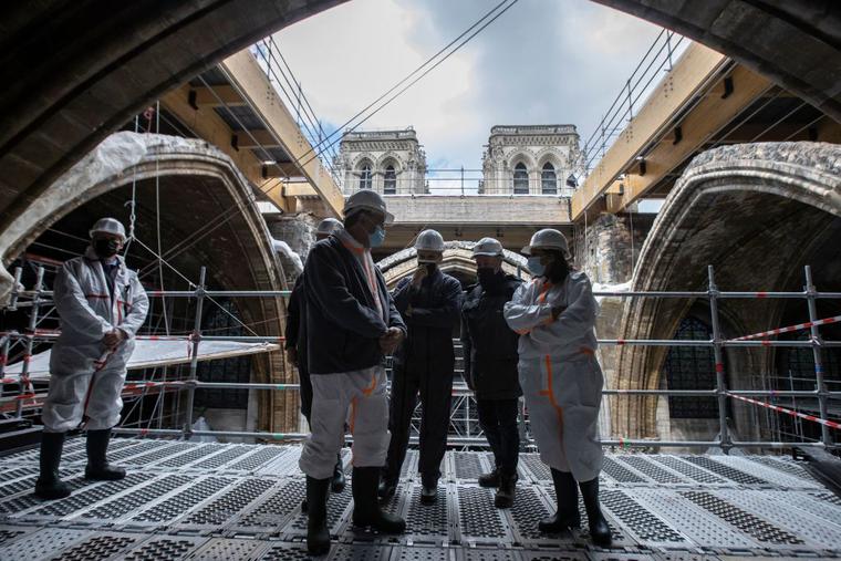 French President Emmanuel Macron (3rd L), the architecte in charge of the restoration Philippe Villeneuve (2nd R), Paris' mayor Anne Hidalgo (R) and Paris' Archbishop Michel Aupetit (2nd L), tour the scaffolding under the vault of Notre-Dame de Paris Cathedral during a visit marking two years since the blaze that made the spire collapsed and destroyed much of the roof, in Paris on April 15, 2021.