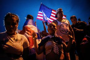 A woman kneels as people block Palmetto Expressway during a protest showing support for Cubans demonstrating against their government, in Miami, on July 13, 2021.