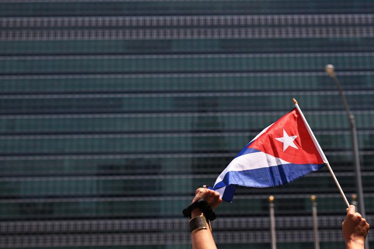 A person holds up a Cuban flag as people gather July 14 in front of the United Nations in New York City ; those gathered were calling for help for Cuban protesters. The island-nation protest has been the largest anti-government protest in decades.