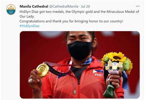 Olympian Hidilyn Diaz holds her gold medal and her Miraculous Medal after her victory, as shown in a tweet from the Manila Cathedral Twitter account.