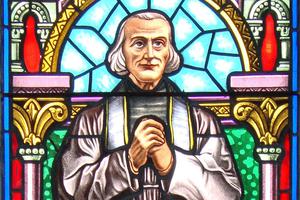 St. John Vianney is depicted in a stained-glass window in Aramits, France. The window was crafted by Pierre Arcencam in 1923.