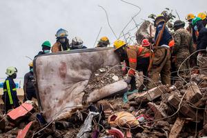 Firefighters remove debris in search of survivors after a 7.2-magnitude earthquake struck Haiti and as tropical storm Grace moves over Jamaica on August 17, 2021 in Les Cayes, Haiti.