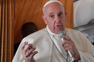 Pope Francis speaks with journalists aboard an airplane from Bratislava, Slovakia, to Rome on Sept. 15.