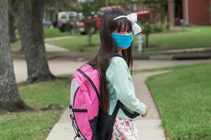 Photo illustration of a student mandated to wear a mask while in class.