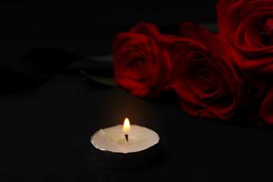 Photo illustration of a red rose and votive candle