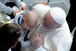Pope Francis hugs a young boy during his general audience address in the Paul VI Hall of the Vatican Oct. 27, 2021