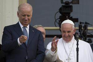 Pope Francis waves, next to US Vice President Joe Biden, on a balcony after speaking at the US Capitol building in Washington, DC on September 24, 2015.