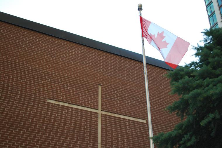 A Canadian flag is seen flying at a Catholic school in Toronto. Pope Francis will visit Canada July 24-30.