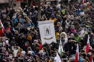 Someone carries a sign with the image of the Blessed Virgin Mary at a rally of people protesting against coronavirus-related restrictions and a coming vaccination mandate on Jan. 9 in Innsbruck, Austria.