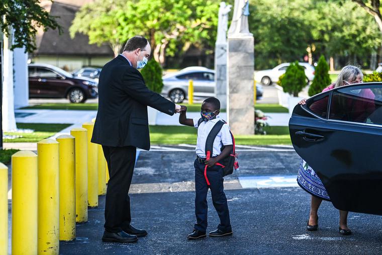 The new Superintendent of Schools for the Archdiocese of Miami, Jim Rigg, greets a student on his first day of school after summer vacation at St. Lawrence Catholic School in Miami, Aug. 18, 2021.