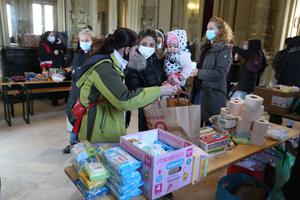 An Ukrainian refugee woman and her daughter receive food and sanitary items at the aid point to help refugees fleeing the Russian invasion in the Ukraine in the Westend railway station in Budapest, on March 1.