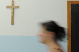 A crucifix is seen on the wall of a Catholic school classroom.