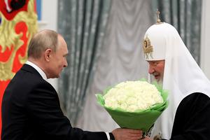 Russia's President Vladimir Putin (l) congratulates Patriarch Kirill of Moscow and all Russia during a presentation ceremony in Moscow on Nov. 20, 2021.