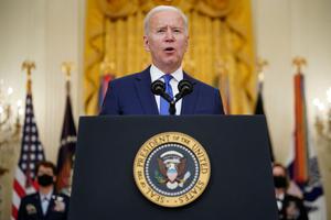 President Joe Biden, flanked by the nominees to positions as four-star generals Gen. Jacqueline Van Ovost (l) and Lt. Gen. Laura Richardson, speaks Tuesday on International Women’s Day in the East Room of the White House in Washington, DC.
