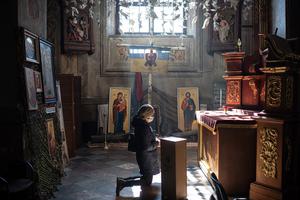 A woman prays at the cathedral after the funeral ceremony for Ukrainian officer Ivan Skrypnyk on March 17 in Lviv, Ukraine. The soldier died in a March 13 Russian airstrike on the nearby International Center for Peacekeeping and Security at the Yavoriv military complex.