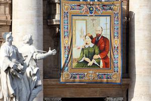 A tapestry featuring the portrait of Sts. Louis and Zélie Martin, the parents of St. Thérèse of Lisieux and the first married couple to be canonized together, is draped from the balcony overlooking St. Peter's Square on Oct. 18, 2015.