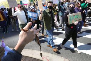 A pro-life supporter holds up a rosary as pro-abortion demonstrators march down Michigan Avenue on Saturday in Chicago.