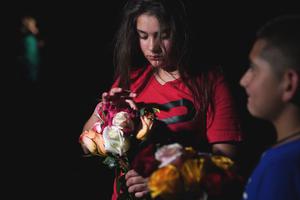 A young girl holds flowers outside the Willie de Leon Civic Center where people gather to mourn in Uvalde, Texas, May 24, 2022.