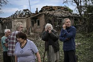 Inhabitants stand in front of destroyed houses after a missile strike, which killed an elderly woman, in the city of Druzhkivka (also written Druzhkovka) in the eastern Ukrainian region of Donbas on June 5.