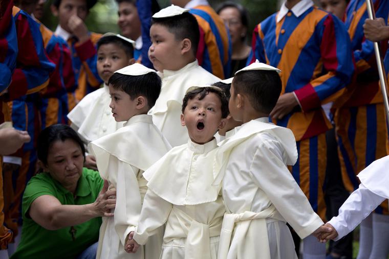 A woman tends to a group of boys dressed in papal attire at an April 27, 2014, event in Manila marking the canonization of John Paul II and John XXIII.