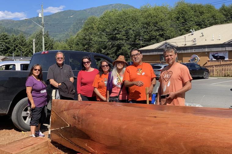 Above, Father Henderson is shown with Pacheedaht friends, elders and carvers, standing by their first carved cedar canoe in 35 years.