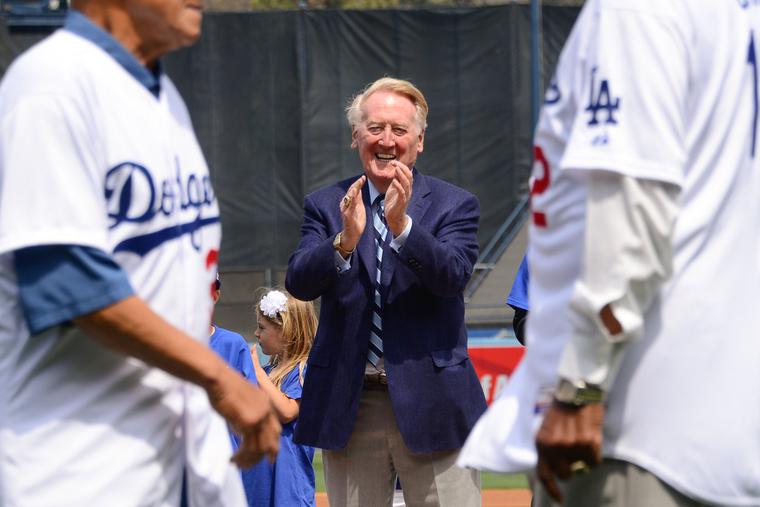 Vin Scully applauds Dodger hall of famers during opening day pre-game ceremonies at a baseball game between the San Francisco Giants and the Los Angeles Dodgers  at Dodger Stadium on April 4, 2014, in Los Angeles, California. Scully died Aug. 2 at the age of 94.