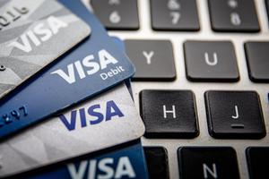 In this photo illustration, Visa cards are seen on a computer keyboard. In this photo illustration, Visa cards are seen on a computer keyboard.