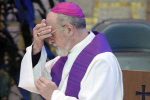Former archbishop of Milwaukee, Wisconsin, Rembert Weakland crosses himself moments before making a public apology for sexual indiscretions during a prayer service May 31, 2002 in St. Francis, Wisconsin.