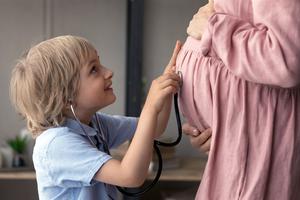 A young boy uses a stethoscope to listen to the heartbeat of his unborn sister or brother.
A young boy uses a stethoscope to listen to the heartbeat of his unborn sister or brother.