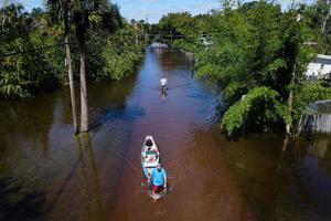 In this aerial view, a man tows a canoe through a flooded street of his neighborhood in New Smyrna Beach, Florida, on September 30, 2022, after Hurricane Ian slammed the area. In this aerial view, a man tows a canoe through a flooded street of his neighborhood in New Smyrna Beach, Florida, on September 30, 2022, after Hurricane Ian slammed the area.