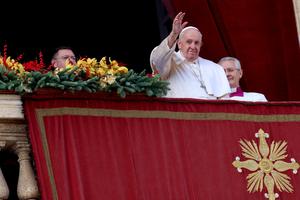 Pope Francis waves to the faithful from the central balcony overlooking  St. Peter's Square on Dec. 25. The Pope greeted the thousands of pilgrims gathered to hear his traditional Christmas Day message in the square on a sunny and mild day for this time of year. 