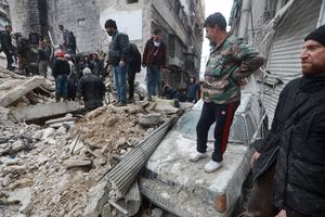 Syrians search for victims and survivors at the rubble a collapsed building in the city of Aleppo following a deadly earthquake on February 6, 2023. 
