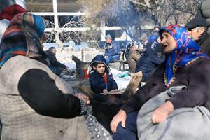 People warm up around a fire in a park in Gaziantep, close to the quake's epicentre, a day after a 7.8-magnitude earthquake struck the country's southeast, on February 7, 2023. 