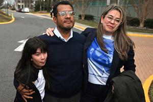 Nicaraguan scholar Felix Maradiaga (c) holds his daughter, Alejandra, 9, and his wife, Berta Valle, outside the Westin Hotel in Herndon, Virginia, on Feb. 9.