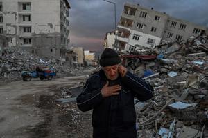 A man speaks on the phone Feb. 21 in front of collapsed buildings, a day after a 6.4-magnitude earthquake struck the region, in the coastal city of Samandag in Turkey's southern province of Hatay, the hardest hit by the Feb. 6 tremor . A man speaks on the phone Feb. 21 in front of collapsed buildings, a day after a 6.4-magnitude earthquake struck the region, in the coastal city of Samandag in Turkey's southern province of Hatay, the hardest hit by the Feb. 6 tremor .