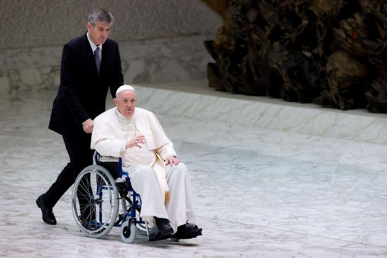 Pope Francis enters the Vatican’s Paul VI Hall in a wheelchair on May 5, 2022.