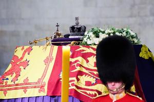 The Imperial State Crown, Sceptre, and wreath of symbolic flowers adorn the coffin of Her Late Majesty Queen Elizabeth II on the gun carriage for the funeral procession, Sept. 19, 2022.