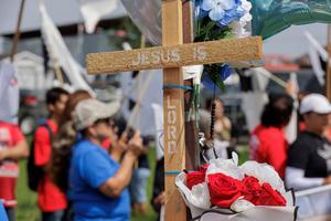 A cross sits displayed during a vigil for 8 migrants that were run over and killed Sunday waiting at a bus stop on May 8, 2023 in Brownsville, Texas. 
