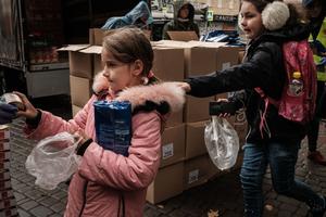 Girls receive food items during its distribution to about 3000 people by the local branch of Caritas Internationalis, a Catholic charity organisation, in Kharkiv on September 27, 2022. 