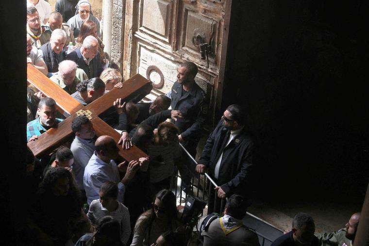 Members of the local Catholic Palestinian parish carry a wooden cross into the church of the Holy Sepulchre in Jerusalem’s Old City during the Good Friday procession on April 7.