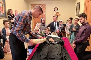 A young man touches a religious statue to the body of Sister Wilhelmina Lancaster on May 18, 2023, at the Benedictines of Mary, Queen of Apostles monastery in Gower, Missouri.