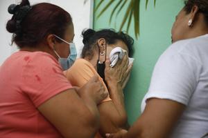 Relatives of inmates wait in distress outside the entrance to the women's prison in Tamara, on the outskirts of Tegucigalpa, Honduras, Tuesday, June 20, 2023. 