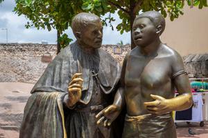 A sculpture honoring the ministry of St. Peter Claver stands in the square named for him in Cartagena, Colombia.