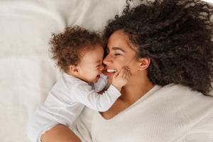 A mother and her baby share a moment of joy. 