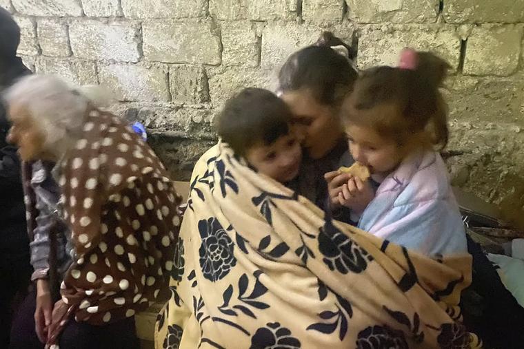 Children eat sitting in a shelter during shelling in Stepanakert in Nagorno-Karabakh. Azerbaijan on Tuesday declared that it started what it called an "anti-terrorist operation" targeting Armenian military positions in the Nagorno-Karabakh region and officials in that region said there was heavy artillery firing around its capital. 