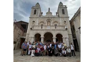 Father Björn Lundberg, center, with the tour group he led to the Holy Land in front of the Wedding Church at Cana.