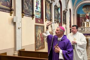 Bishop Robert Brennan blesses Annunciation of the Blessed Virgin Mary Church in Brooklyn, New York, with holy water on Nov. 4, 2023, in response to the filming of an indecent music video in the church. Assisting the bishop is Monsignor Joseph Grimaldi, vicar general of the Diocese of Brooklyn.